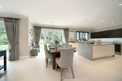 Photo of a contemporary u-shaped open plan kitchen in Dorset with a built-in sink, flat-panel cabinets, granite worktops, grey splashback, stainless steel appliances, porcelain flooring and an island.