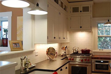 Foto de cocina de estilo americano con armarios estilo shaker, puertas de armario blancas, salpicadero blanco, salpicadero de azulejos tipo metro, suelo de madera en tonos medios y una isla