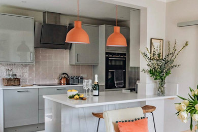 Design ideas for a contemporary kitchen/diner in Gloucestershire with flat-panel cabinets, grey cabinets, quartz worktops, white splashback, stainless steel appliances, limestone flooring and white worktops.