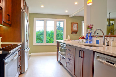 Example of a mid-sized transitional galley vinyl floor kitchen design in Ottawa with an undermount sink, shaker cabinets, brown cabinets, quartz countertops, white backsplash, porcelain backsplash and stainless steel appliances