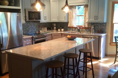 Inspiration for a mid-sized transitional l-shaped light wood floor and beige floor open concept kitchen remodel in Other with a double-bowl sink, recessed-panel cabinets, blue cabinets, multicolored backsplash, matchstick tile backsplash, stainless steel appliances, an island and granite countertops