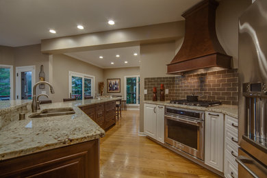 Inspiration for a large transitional l-shaped medium tone wood floor and brown floor eat-in kitchen remodel in Milwaukee with an undermount sink, raised-panel cabinets, dark wood cabinets, granite countertops, red backsplash, porcelain backsplash, stainless steel appliances and an island