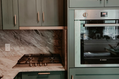 タンパにあるお手頃価格の小さなコンテンポラリースタイルのおしゃれなキッチン (アンダーカウンターシンク、シェーカースタイル扉のキャビネット、緑のキャビネット、大理石カウンター、グレーのキッチンパネル、大理石のキッチンパネル、シルバーの調理設備、無垢フローリング、グレーのキッチンカウンター) の写真