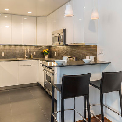 Inspiration for a contemporary kitchen remodel in New York with flat-panel cabinets, white cabinets, gray backsplash and stainless steel appliances