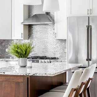 Imagen de cocina comedor en L, minimalista, de tamaño medio, con una isla, armarios estilo shaker, puertas de armario blancas, encimera de granito, salpicadero metalizado, salpicadero de metal, electrodomésticos de acero inoxidable, suelo de madera oscura y suelo marrón