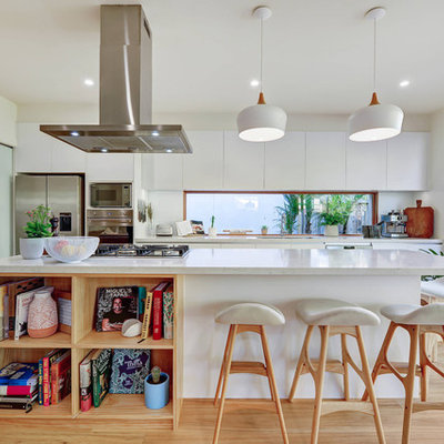 Kitchen - contemporary galley medium tone wood floor and brown floor kitchen idea in Sydney with an undermount sink, flat-panel cabinets, white cabinets, white backsplash, window backsplash, stainless steel appliances, an island and white countertops
