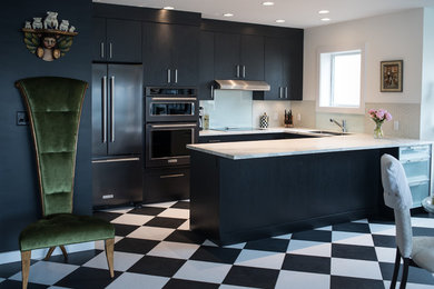 This is an example of a small contemporary u-shaped kitchen/diner in Vancouver with a submerged sink, flat-panel cabinets, black cabinets, glass tiled splashback, black appliances, vinyl flooring and a breakfast bar.