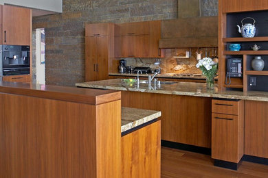 Inspiration for a contemporary u-shaped eat-in kitchen remodel in San Francisco with an undermount sink, flat-panel cabinets, medium tone wood cabinets, granite countertops, multicolored backsplash, stone slab backsplash and stainless steel appliances