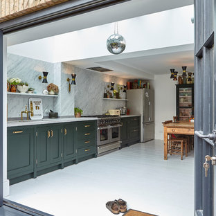 Photo of a classic single-wall kitchen/diner in London with shaker cabinets, green cabinets, white splashback, stone slab splashback, stainless steel appliances, painted wood flooring, no island, white floors and white worktops.