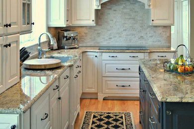 Example of a large transitional l-shaped medium tone wood floor and brown floor eat-in kitchen design in Boston with stone tile backsplash, an island, an undermount sink, raised-panel cabinets, white cabinets, granite countertops, beige backsplash and stainless steel appliances