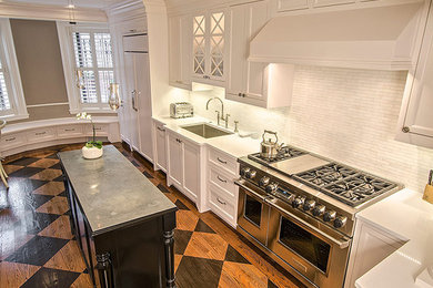 Example of a transitional kitchen design in Boston with an undermount sink, quartz countertops, white cabinets, white backsplash and an island