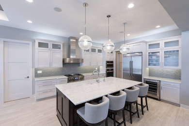 Open concept kitchen - mid-sized contemporary l-shaped porcelain tile open concept kitchen idea in Other with shaker cabinets, white cabinets, granite countertops, gray backsplash, mosaic tile backsplash, stainless steel appliances and an island