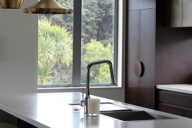 Mittelgroße Moderne Küche in L-Form mit flächenbündigen Schrankfronten, Marmor-Arbeitsplatte, Küchengeräten aus Edelstahl, Kücheninsel, weißer Arbeitsplatte, Küchenrückwand in Weiß und Rückwand aus Marmor in Auckland