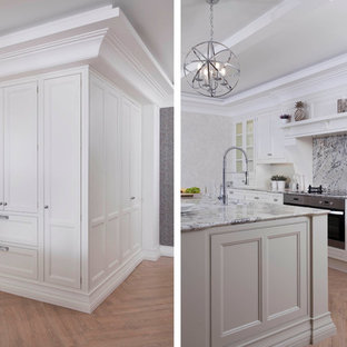 Photo of a large traditional l-shaped separate kitchen in Dublin with an undermount sink, louvered cabinets, beige cabinets, granite benchtops, multi-coloured splashback, stone slab splashback, stainless steel appliances, porcelain floors and with island.