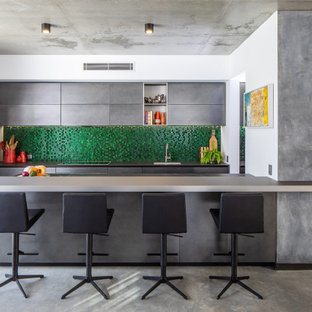 This is an example of a large contemporary open plan kitchen in Perth with an undermount sink, green splashback, glass tile splashback, panelled appliances, concrete floors, with island and grey benchtop.