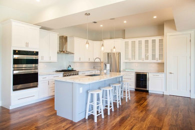 Inspiration for a large contemporary l-shaped medium tone wood floor open concept kitchen remodel in Hawaii with an undermount sink, shaker cabinets, white cabinets, marble countertops, white backsplash, stainless steel appliances and an island