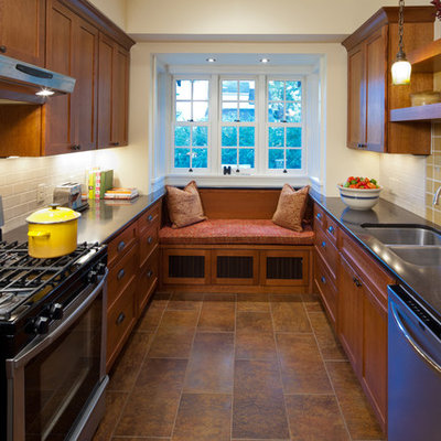 Example of a mid-sized arts and crafts u-shaped porcelain tile enclosed kitchen design in Minneapolis with an undermount sink, shaker cabinets, medium tone wood cabinets, solid surface countertops, yellow backsplash, ceramic backsplash and stainless steel appliances