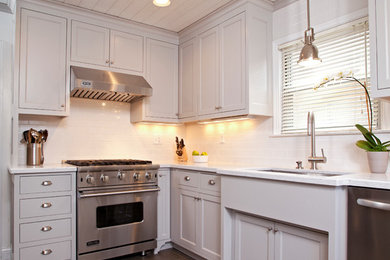 Mid-sized elegant l-shaped porcelain tile and gray floor eat-in kitchen photo in Minneapolis with an undermount sink, recessed-panel cabinets, gray cabinets, solid surface countertops, white backsplash, ceramic backsplash, stainless steel appliances and no island