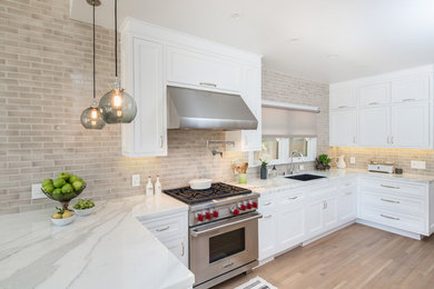 Example of a mid-sized classic l-shaped light wood floor and multicolored floor eat-in kitchen design in Los Angeles with a single-bowl sink, beaded inset cabinets, white cabinets, marble countertops, ceramic backsplash and stainless steel appliances