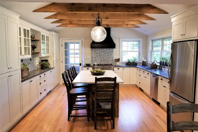 Eat-in kitchen - mid-sized farmhouse u-shaped medium tone wood floor and brown floor eat-in kitchen idea with an undermount sink, shaker cabinets, white cabinets, quartz countertops, multicolored backsplash, porcelain backsplash, stainless steel appliances, an island and gray countertops