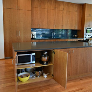 Inspiration for a huge modern single-wall medium tone wood floor open concept kitchen remodel in Denver with an undermount sink, flat-panel cabinets, medium tone wood cabinets, black backsplash, stainless steel appliances and an island