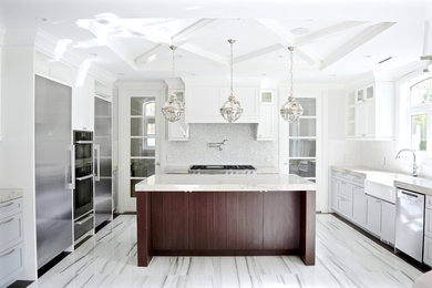 Design ideas for a large traditional u-shaped kitchen/diner in Vancouver with a belfast sink, shaker cabinets, blue cabinets, limestone worktops, white splashback, glass tiled splashback, stainless steel appliances, porcelain flooring, an island, multi-coloured floors and beige worktops.