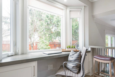 Inspiration for a mid-sized transitional u-shaped linoleum floor and brown floor eat-in kitchen remodel in Vancouver with a farmhouse sink, shaker cabinets, white cabinets, quartzite countertops, white backsplash, subway tile backsplash, stainless steel appliances, an island and multicolored countertops