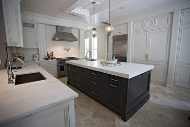 Exempel på ett stort eklektiskt kök, med en undermonterad diskho, luckor med infälld panel, grå skåp, marmorbänkskiva, vitt stänkskydd, stänkskydd i porslinskakel, rostfria vitvaror, travertin golv och en köksö