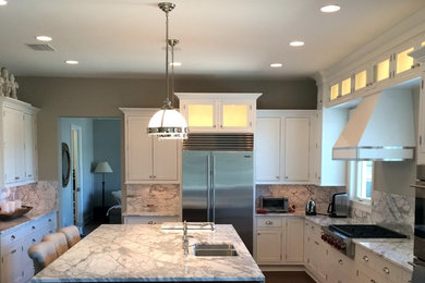 This is an example of a large traditional u-shaped kitchen/diner in Tampa with a double-bowl sink, shaker cabinets, white cabinets, marble worktops, multi-coloured splashback, stone slab splashback, stainless steel appliances, dark hardwood flooring, an island and brown floors.