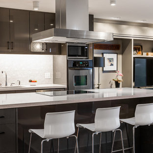 Contemporary open concept kitchen designs - Inspiration for a contemporary galley light wood floor open concept kitchen remodel in Salt Lake City with an undermount sink, flat-panel cabinets, gray cabinets, white backsplash, stainless steel appliances and an island