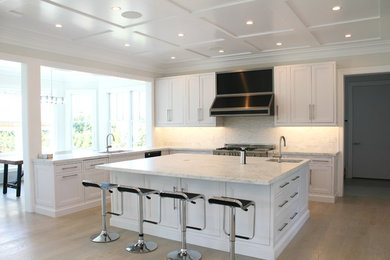 Example of a large minimalist eat-in kitchen design in New York with an undermount sink, shaker cabinets, white cabinets, marble countertops, white backsplash, stone tile backsplash, stainless steel appliances and an island