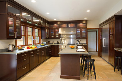 Large trendy l-shaped open concept kitchen photo in New York with recessed-panel cabinets, dark wood cabinets, concrete countertops and two islands