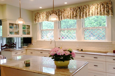 Eat-in kitchen - mid-sized traditional l-shaped medium tone wood floor and brown floor eat-in kitchen idea in Boston with an undermount sink, recessed-panel cabinets, beige cabinets, quartzite countertops, beige backsplash, subway tile backsplash, paneled appliances and an island