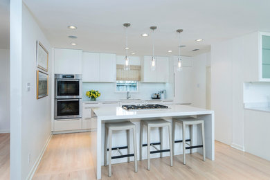 Inspiration for a modern light wood floor eat-in kitchen remodel in Dallas with a single-bowl sink, flat-panel cabinets, white cabinets, quartz countertops, white backsplash, ceramic backsplash, stainless steel appliances and an island