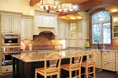 Large farmhouse u-shaped eat-in kitchen photo in New Orleans with an undermount sink, beaded inset cabinets, white cabinets, granite countertops, brown backsplash, ceramic backsplash, stainless steel appliances and an island