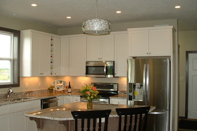 Foto di una cucina chic con lavello sottopiano, ante lisce, ante bianche, top in granito e elettrodomestici in acciaio inossidabile