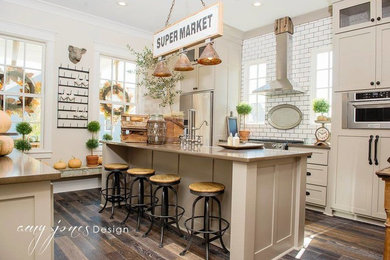 Mid-sized country medium tone wood floor enclosed kitchen photo in Little Rock with a farmhouse sink, shaker cabinets, gray cabinets, quartz countertops, white backsplash, subway tile backsplash, stainless steel appliances and an island