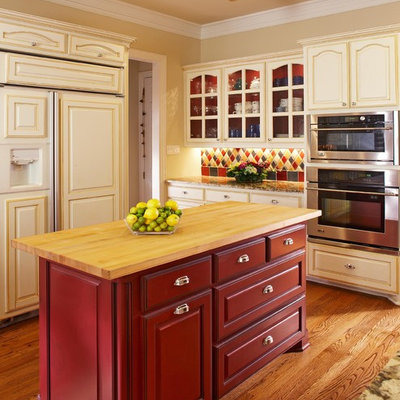 Kitchen - traditional kitchen idea in Dallas with glass-front cabinets, wood countertops and red cabinets