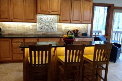 コロンバスにあるサンタフェスタイルのおしゃれなキッチン (中間色木目調キャビネット、御影石カウンター、マルチカラーのキッチンパネル、セラミックタイルの床、ベージュの床) の写真