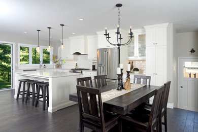 Large transitional l-shaped dark wood floor eat-in kitchen photo in Toronto with a double-bowl sink, shaker cabinets, white cabinets, marble countertops, yellow backsplash, subway tile backsplash, stainless steel appliances and an island