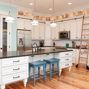 Traditional kitchen ideas - Inspiration for a timeless l-shaped light wood floor kitchen remodel in Wilmington with white backsplash, subway tile backsplash and white cabinets