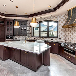 Photo of a large traditional eat-in kitchen in Oklahoma City with a farmhouse sink, recessed-panel cabinets, brown cabinets, quartzite benchtops, multi-coloured splashback, porcelain splashback, stainless steel appliances, porcelain floors, with island, green floor and white benchtop.