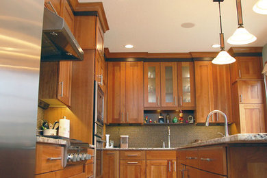 Example of a mid-sized trendy l-shaped medium tone wood floor kitchen design in Other with an undermount sink, shaker cabinets, medium tone wood cabinets, granite countertops, metallic backsplash, mosaic tile backsplash, stainless steel appliances and an island