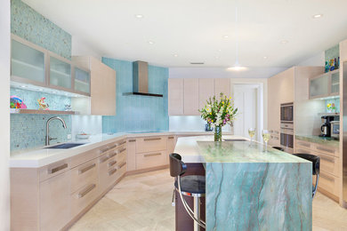 This is an example of a large contemporary u-shaped enclosed kitchen in Miami with a submerged sink, flat-panel cabinets, beige cabinets, marble worktops, blue splashback, glass tiled splashback, stainless steel appliances, porcelain flooring, an island, beige floors and multicoloured worktops.