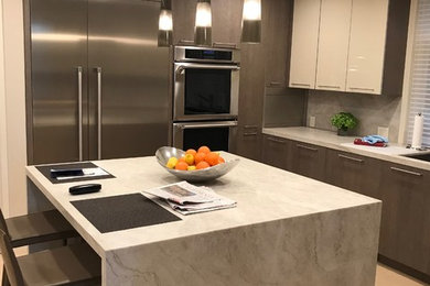Example of a minimalist u-shaped light wood floor and beige floor enclosed kitchen design in Portland with flat-panel cabinets, brown cabinets, an island, an undermount sink, quartz countertops, quartz backsplash, stainless steel appliances, multicolored backsplash and multicolored countertops