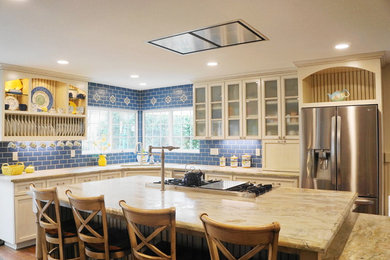 Foto på ett mellanstort medelhavsstil kök, med en undermonterad diskho, luckor med glaspanel, vita skåp, bänkskiva i kalksten, blått stänkskydd, stänkskydd i tunnelbanekakel, rostfria vitvaror, mellanmörkt trägolv, en köksö och brunt golv
