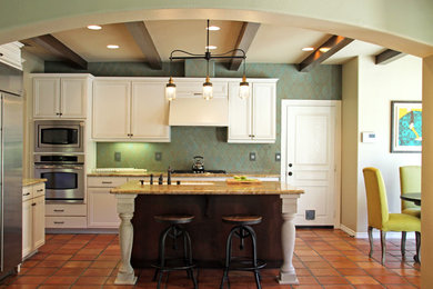 Inspiration for a mid-sized mediterranean l-shaped terra-cotta tile and orange floor eat-in kitchen remodel in San Luis Obispo with an undermount sink, raised-panel cabinets, white cabinets, quartz countertops, green backsplash, ceramic backsplash, stainless steel appliances and an island