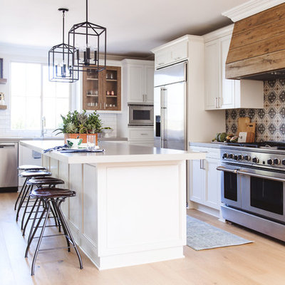 Inspiration for a mid-sized transitional l-shaped light wood floor and beige floor open concept kitchen remodel in San Diego with recessed-panel cabinets, white cabinets, multicolored backsplash, cement tile backsplash, stainless steel appliances, an island, an undermount sink and quartzite countertops