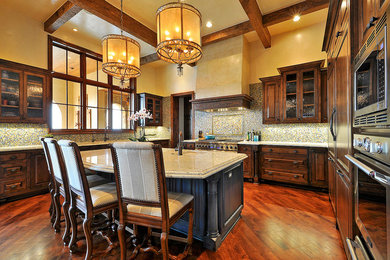 Eat-in kitchen - rustic u-shaped medium tone wood floor eat-in kitchen idea in Austin with a drop-in sink, granite countertops, paneled appliances and an island