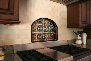 На фото: прямая кухня в средиземноморском стиле с темными деревянными фасадами, гранитной столешницей, желтым фартуком, фартуком из терракотовой плитки и техникой из нержавеющей стали с